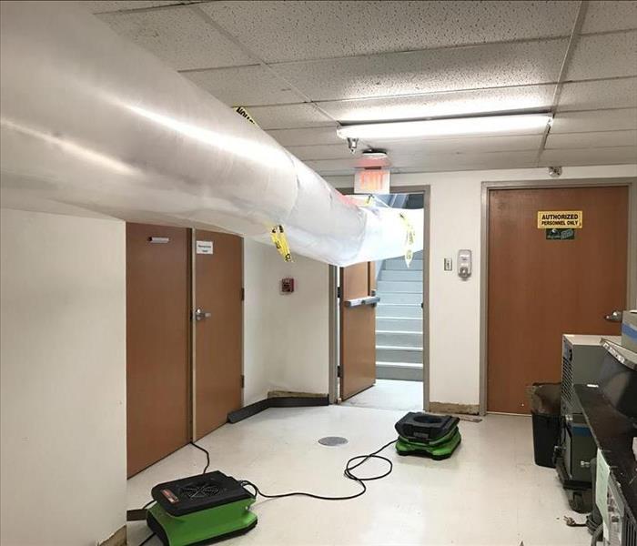 Air movers set up in a hallway.