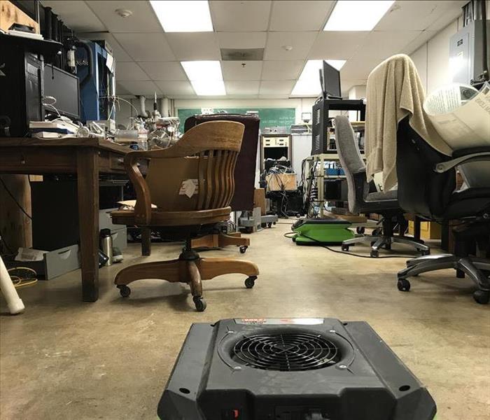 Office room with one air mover situated in the middle.