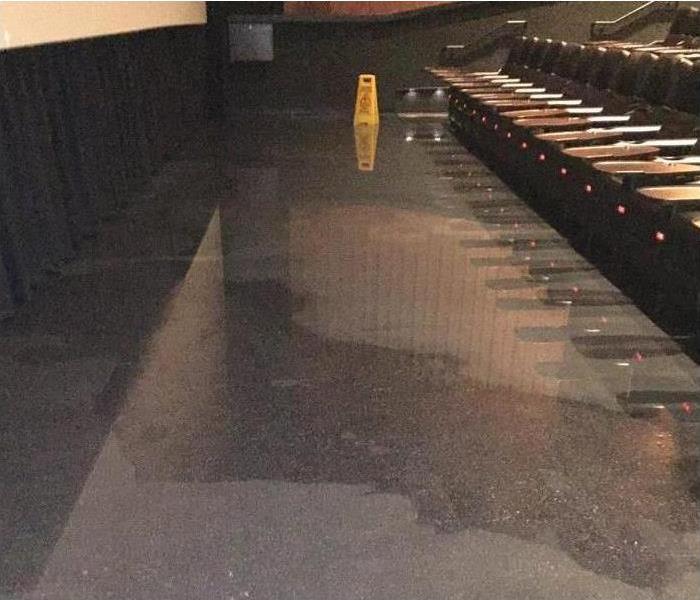 Large water puddle on floor of theater. 