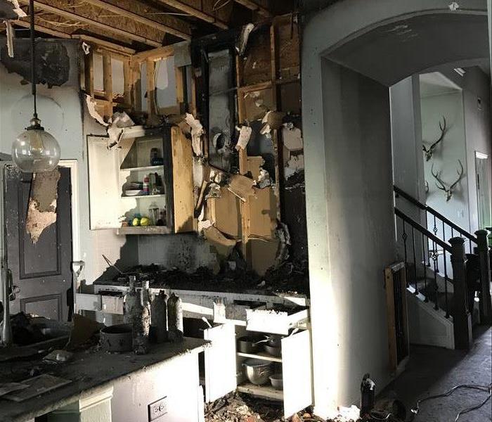 Burned kitchen filled with ashes and with the ceiling collapsed.